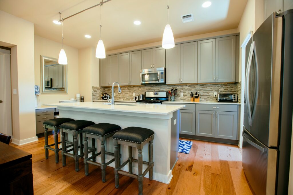 Modern home kitchen with green grey fitted units and kitchen island